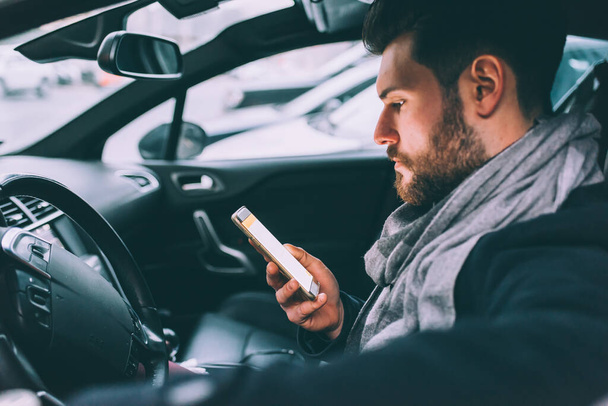 jeune homme d'affaires barbu assis voiture téléphone intelligent - Photo, image
