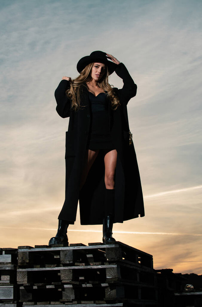 Sexy woman in black fashion coat, hat and black shoes boots. Beautiful young woman wearing fashionable spring clothes. Portrait of the fashion model in trendy dress - Φωτογραφία, εικόνα