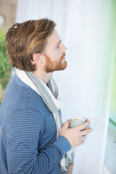 homem com café olhando pela janela - Foto, Imagem