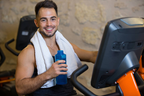 happy and smiling sportman over gym machines - Foto, Imagen