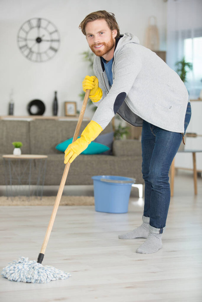 young man mopping floor - Foto, immagini