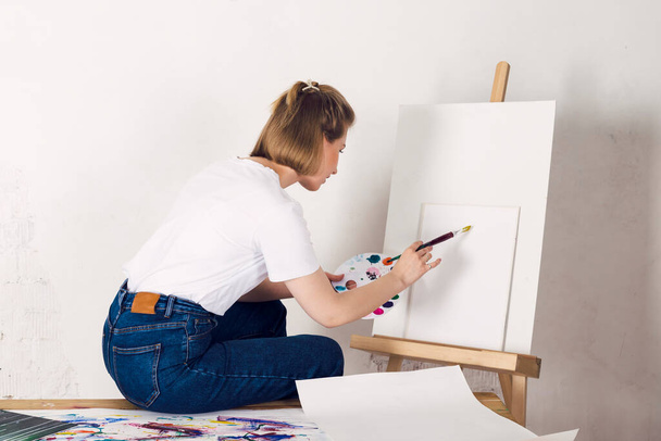 The art school student is painting on a canvas. - Valokuva, kuva