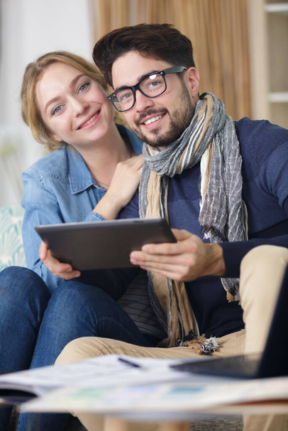 couple on sofa with digital tablet - Фото, изображение
