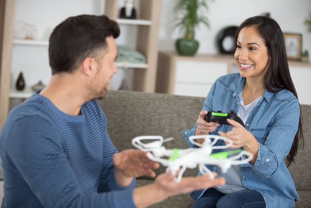 young couple playing with a small quadrocopter drone - Foto, immagini