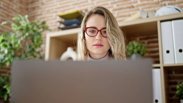 Young blonde woman business worker using laptop working at office - 写真・画像
