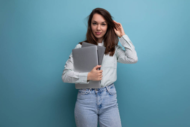 ευρωπαϊκή λεπτή 25χρονη νεαρή καστανή επιχειρηματίας που κρατά ένα φορητό υπολογιστή για το σχεδιασμό. - Φωτογραφία, εικόνα