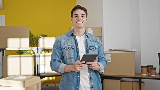 Młody latynoski człowiek e-commerce pracownik za pomocą touchpad w biurze - Zdjęcie, obraz
