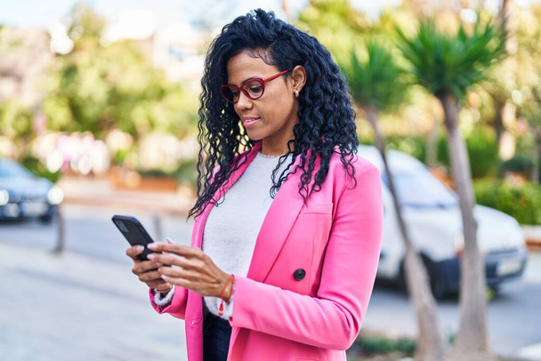 Африканская американка использует смартфон в парке - Фото, изображение