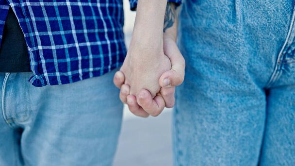 Man and woman couple standing with hands together at street - Photo, Image