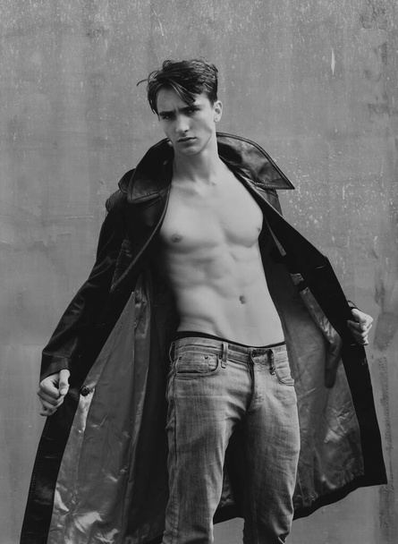 Модель из моды. Портрет шикарного модного человека в кожаном пальто, черной одежде, модном хипстере. Красивый парень с уверенным лицом - Фото, изображение