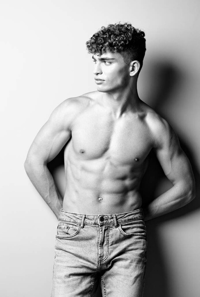 mies valkoihoinen terve valkoinen studio kehon vahva muoti bicep lihaksikas farkut kehonrakentaja tyylikäs istuvuus trendikäs tausta musta - Valokuva, kuva
