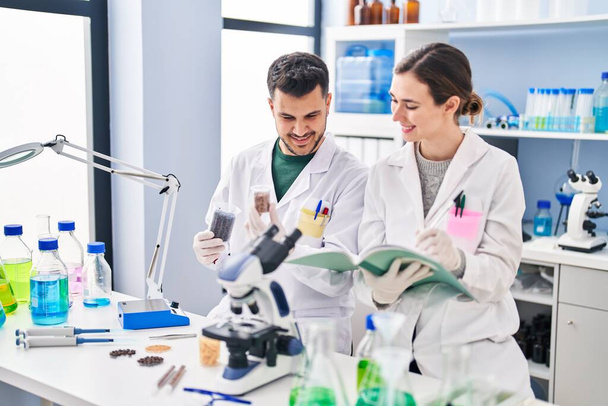 Man and woman wearing scientist uniform working at laboratory - Zdjęcie, obraz