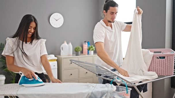 Mann und Frau hängen und bügeln Wäsche in Waschküche - Foto, Bild