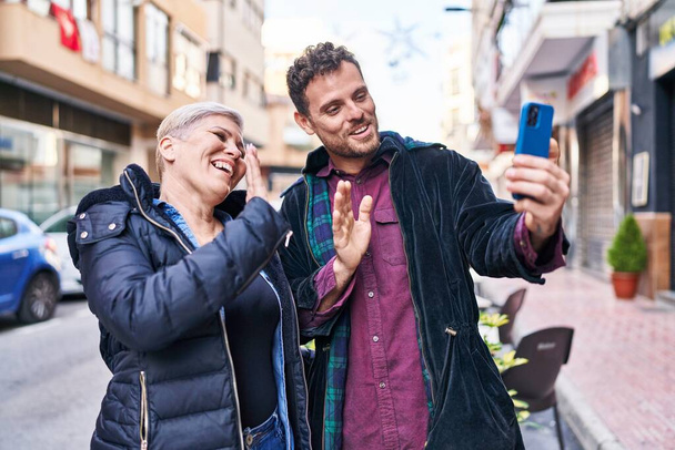 Mère et fils souriant confiants ayant appel vidéo à la rue - Photo, image