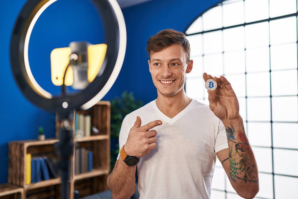 Běloch nahrávání bitcoin tutorial s smartphonem doma s úsměvem šťastný ukazování rukou a prstem  - Fotografie, Obrázek