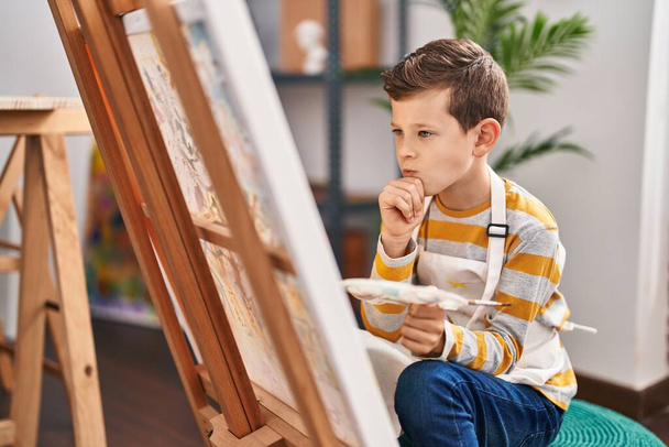 Blond child drawing with doubt expression at art studio - Φωτογραφία, εικόνα
