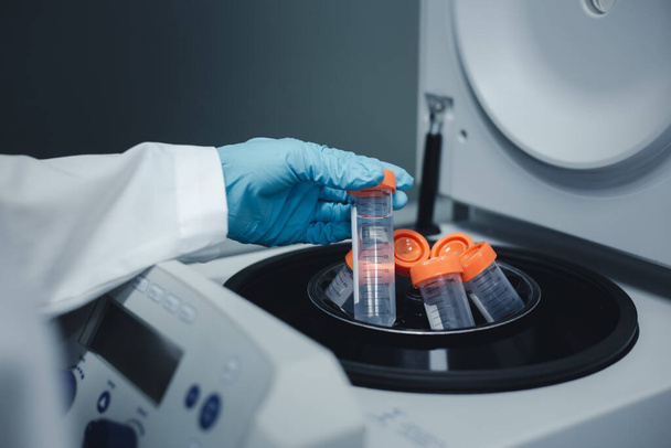 Researchers put the test tube of DNA extraction from Ecoli into a centrifuge machine to separate the DNA from the solution during DNA research. - Foto, Imagem