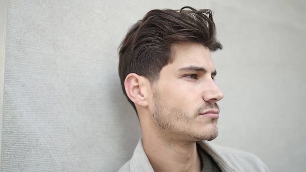 Fiatal spanyol férfi áll komoly kifejezés elszigetelt fehér háttér - Fotó, kép