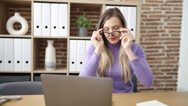 Nuori blondi nainen liiketoiminnan työntekijä käyttää kannettavaa tietokonetta stressaantunut toimistossa - Valokuva, kuva