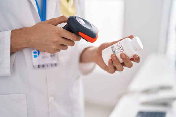 Young blond man pharmacist scanning pills bottle at pharmacy - Foto, Imagem
