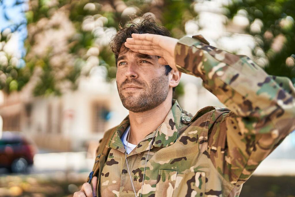 Joven soldado del ejército haciendo saludo militar en el parque - Foto, imagen