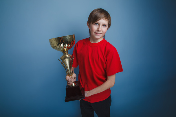 teenager boy twelve years old European appearance holds a cup on - Photo, Image