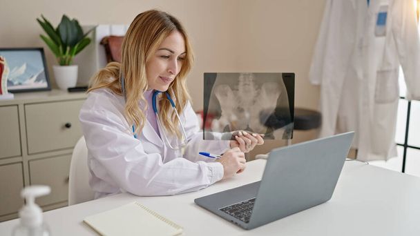 Giovane bella donna ispanica medico avendo videochiamata mostrando raggi X in clinica - Foto, immagini