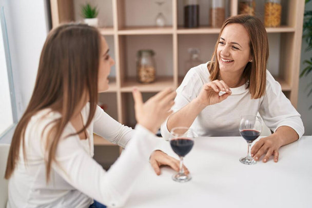 Dwie kobiety matka i córka piją kieliszek wina w domu - Zdjęcie, obraz