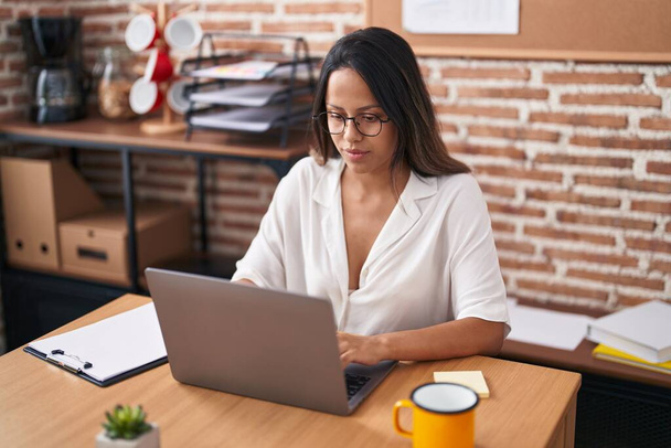 Молода іспанка бізнесмен використовує ноутбук, що працює в офісі
 - Фото, зображення