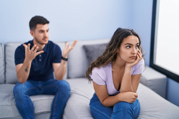 Young hispanic couple arguing sitting on sofa at home - Foto, imagen