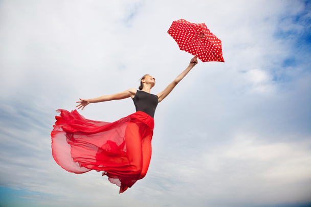 Mladá žena létání na obloze s deštníkem  - Fotografie, Obrázek