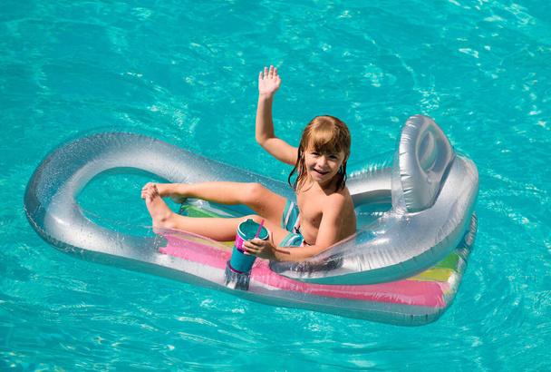 Summertime. Summer vacation. Kid in swimmingpool. Aquapark. Happy child boy on inflatable rubber mattress - Fotó, kép