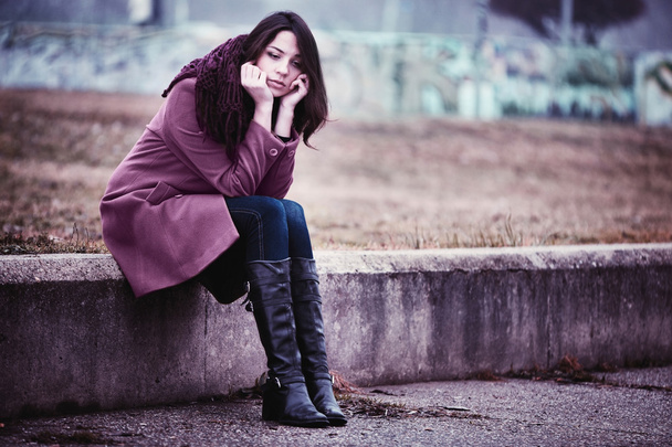 Sad Young Woman Sitting Outdoors - Фото, изображение