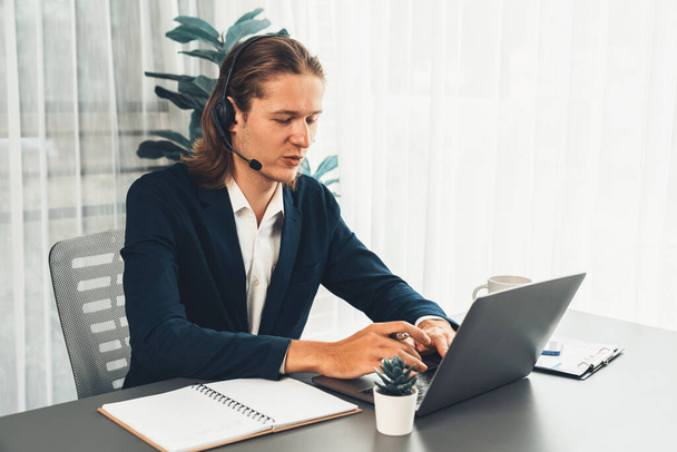 Male customer service operator or telesales agent sitting at desk in office, wearing headset and engage in conversation with client to provide support or close sales. Call center portrait. Entity - Photo, Image