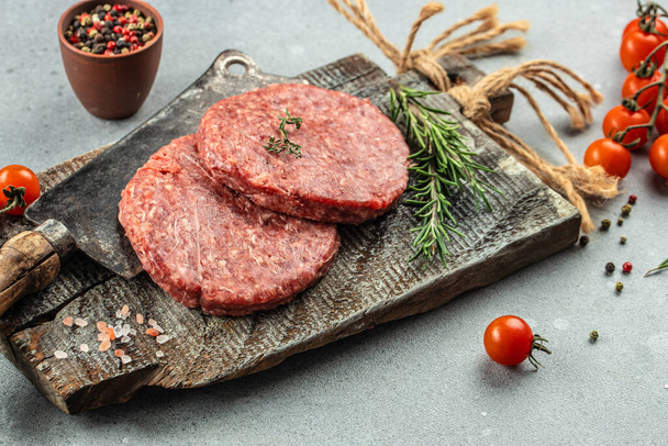 Πρώτου εδάφους κρέας κρέατος Burger μπριζόλα κοτολέτες σε ένα ξύλινο διοικητικό συμβούλιο, Τροφίμων συνταγή φόντο. Κλείσε., - Φωτογραφία, εικόνα