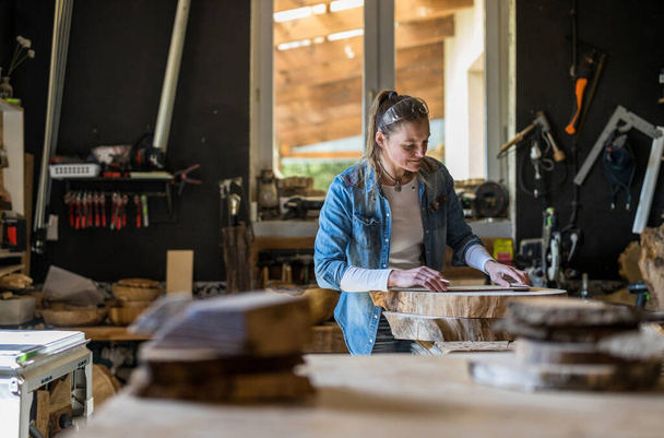 Craftswoman working with wood in carpentry workshop - Foto, imagen