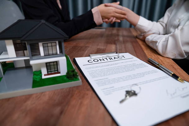 Erfolgreicher Hauskreditvertrag per Handschlag besiegelt Käufer und Makler zelebrieren das Eigentum an Immobilien mit einem Gefühl der Erfüllung und Zufriedenheit. Enthusiastisch - Foto, Bild