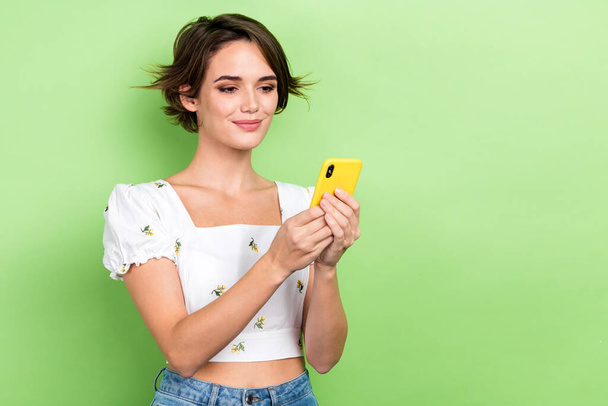 Photo of cheerful positive lady wear white blouse chatting instagram twitter telegram facebook empty space isolated green color background. - 写真・画像