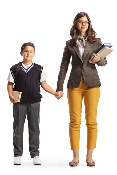 Full length portrait of a female teacher holding hand with a schoolboy isolated on white background - Fotografie, Obrázek