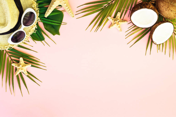 Kesälomat vaaleanpunaisella taustalla. Palmunlehdet, kookos, hattu ja kuoret vaaleanpunaisella pohjalla. - Valokuva, kuva