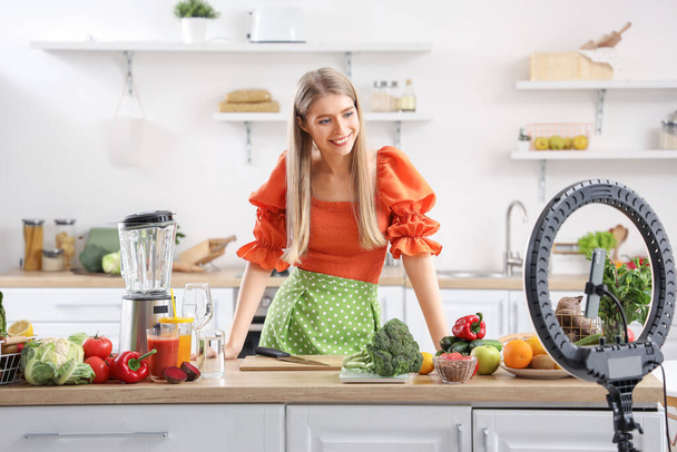 blogger femenina con verduras frescas grabando video de cocina en la cocina - Foto, imagen