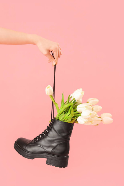 Female hand with tulip flowers in shoes on pink background - Foto, imagen
