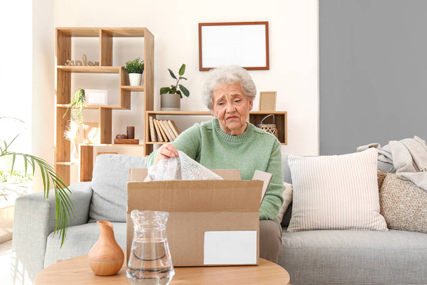 Mujer mayor abriendo parcela en casa - Foto, imagen