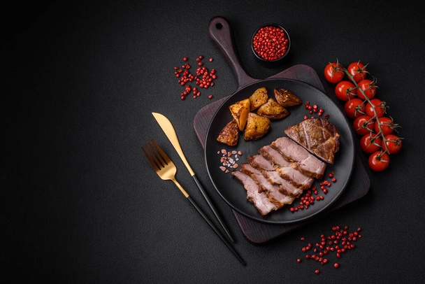 Delicious juicy pork or beef steak grilled with salt, spices and herbs on a textured concrete background - Photo, Image