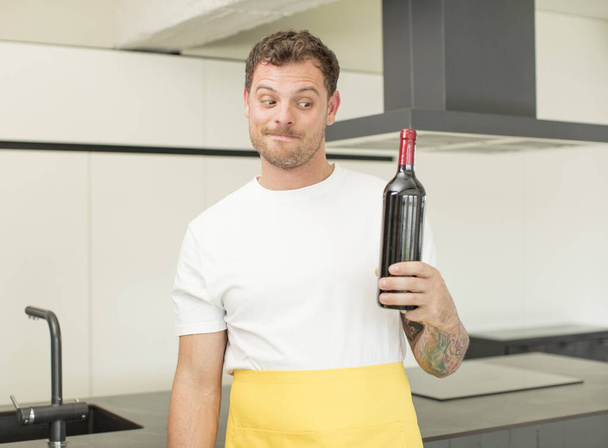 smiling and looking with a happy confident expression. bottle of wine concept - 写真・画像