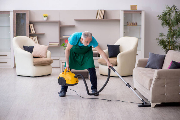 Old contractor cleaning the house - Foto, Bild