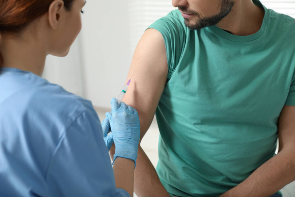 Lekarz podający pacjentowi szczepionkę przeciw wirusowemu zapaleniu wątroby w klinice, zbliżenie - Zdjęcie, obraz