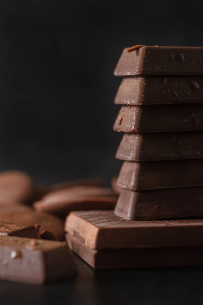 Stack of milk chocolate on dark background. Dessert food background. - Фото, изображение