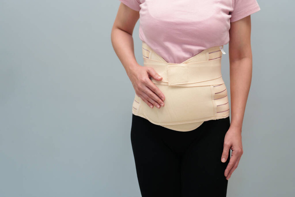 woman wearing lumbar support belts. pregnant and postnatal lumbar brace after surgery - Valokuva, kuva