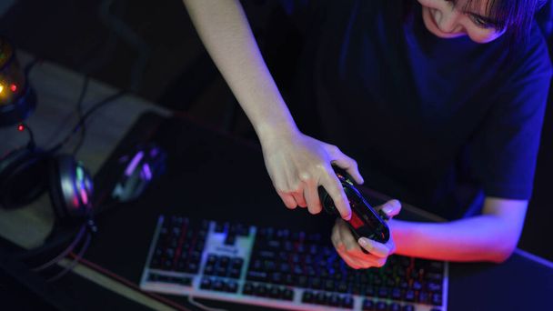 Nainen cyber hakkeri gamer pelaa tai streaming videopelejä tietokoneella joystick neon valossa. - Valokuva, kuva